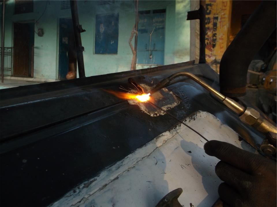 A cutting torch throwing sparks across steel