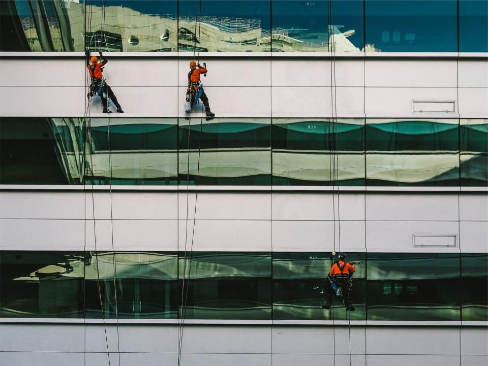Rope-access cleaners washing the windows of an office building